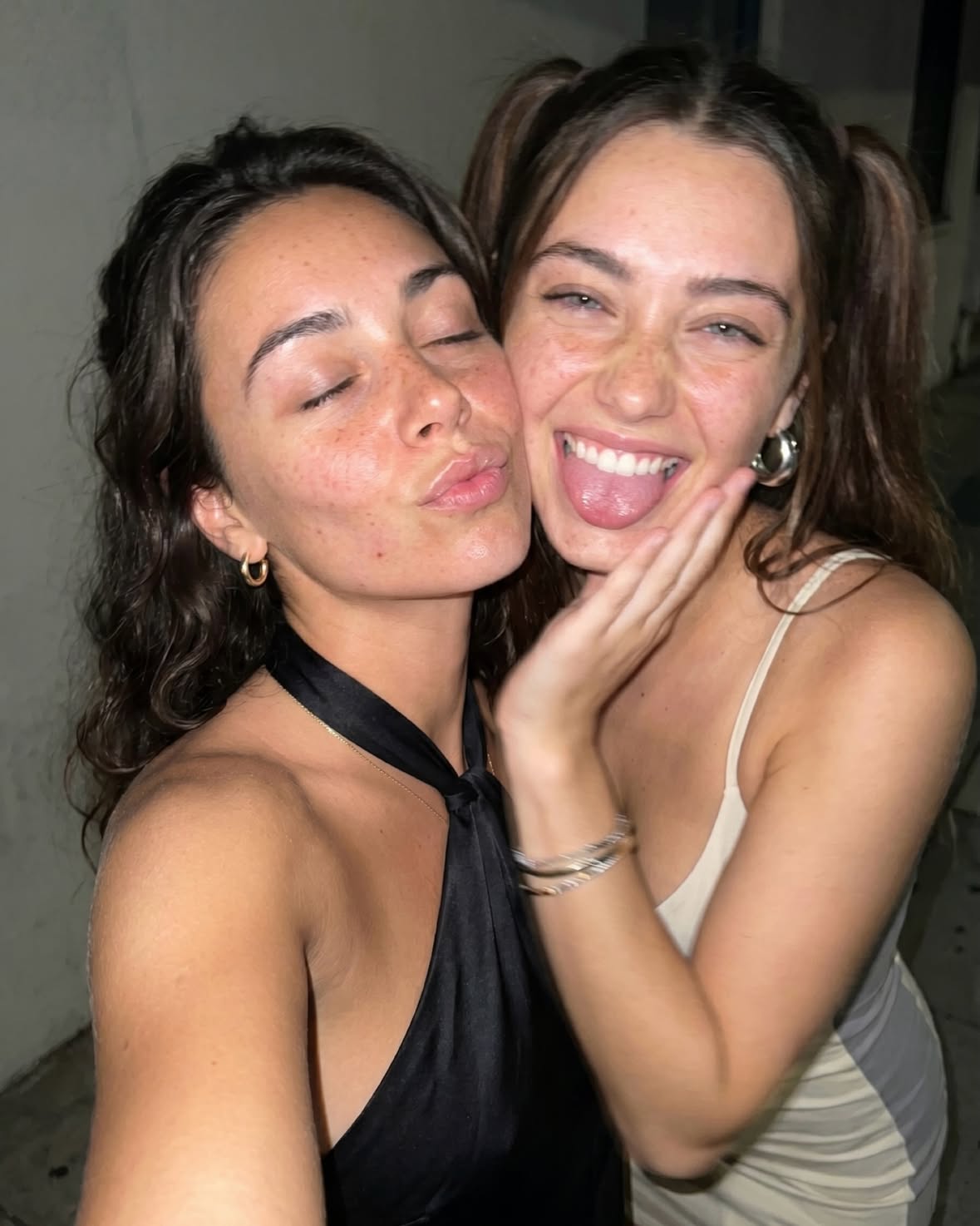 Two cousins during a chaotic Milan night out — dressed elegantly inside crowded clubs, taking flash mirror selfies, sitting exhausted in taxis and ending the night eating street food together with messy makeup and tired smiles.