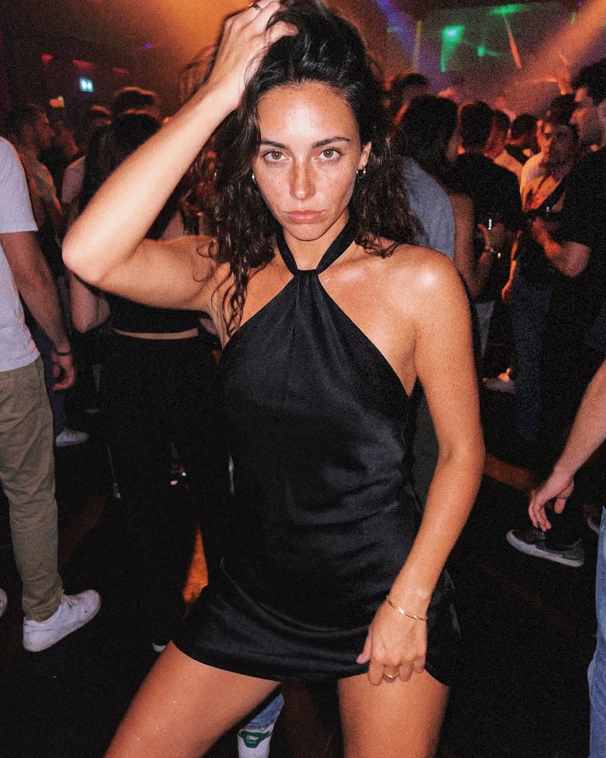 Two cousins during a chaotic Milan night out — dressed elegantly inside crowded clubs, taking flash mirror selfies, sitting exhausted in taxis and ending the night eating street food together with messy makeup and tired smiles.