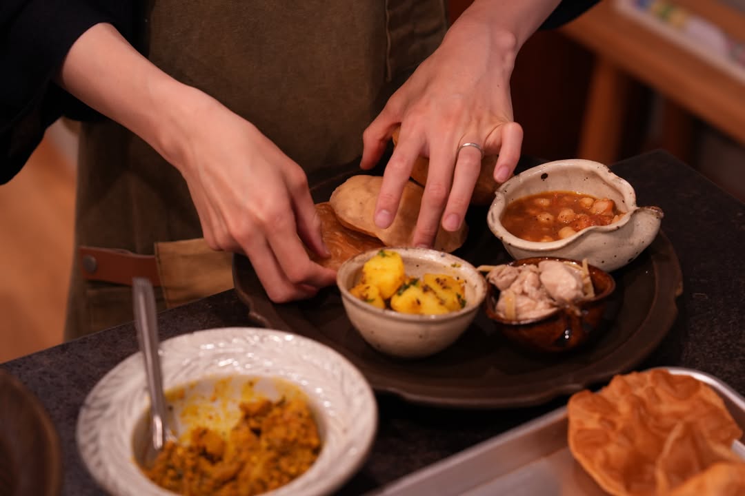 古谷製陶所kitchen、今日は@11020daidokoro ゆみ先生による「北インド料理教室」でした。初めて出会う料理ばかりだったのに、ひと口食べた瞬間から「おいしい…！」と声が漏れてしまうような、そんな時間。特に印象的だったのはチャナマサラ。ひよこ豆のほくっとした食感に、タマリンドの酸味がすっと重なって、あと引くおいしさでした。そして、揚げたてのプーリー。生地がふわっときれいに膨らむたびに歓声が上がって、その場の空気までふわっと明るくなるようでした。じゃがいもの副菜もスパイシーでプーリーと良く合いました！古谷製陶所のうつわに盛りつけられることで、食卓の景色までどこか旅をしているようでした。ご参加くださった皆さま、ゆみ先生、ありがとうございました。次回は9月9日を予定しております。またこの香りとおいしさを囲めるのを楽しみにしています。#古谷製陶所kitchen#古谷製陶所#インドの台所#北インド料理 by @hirokazu_furutani